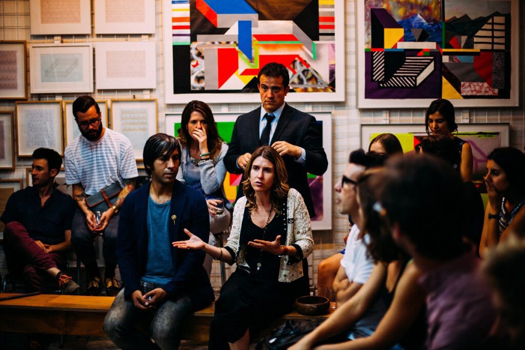 Grupo de pessoas conversando no que parece ser um roda de discussão