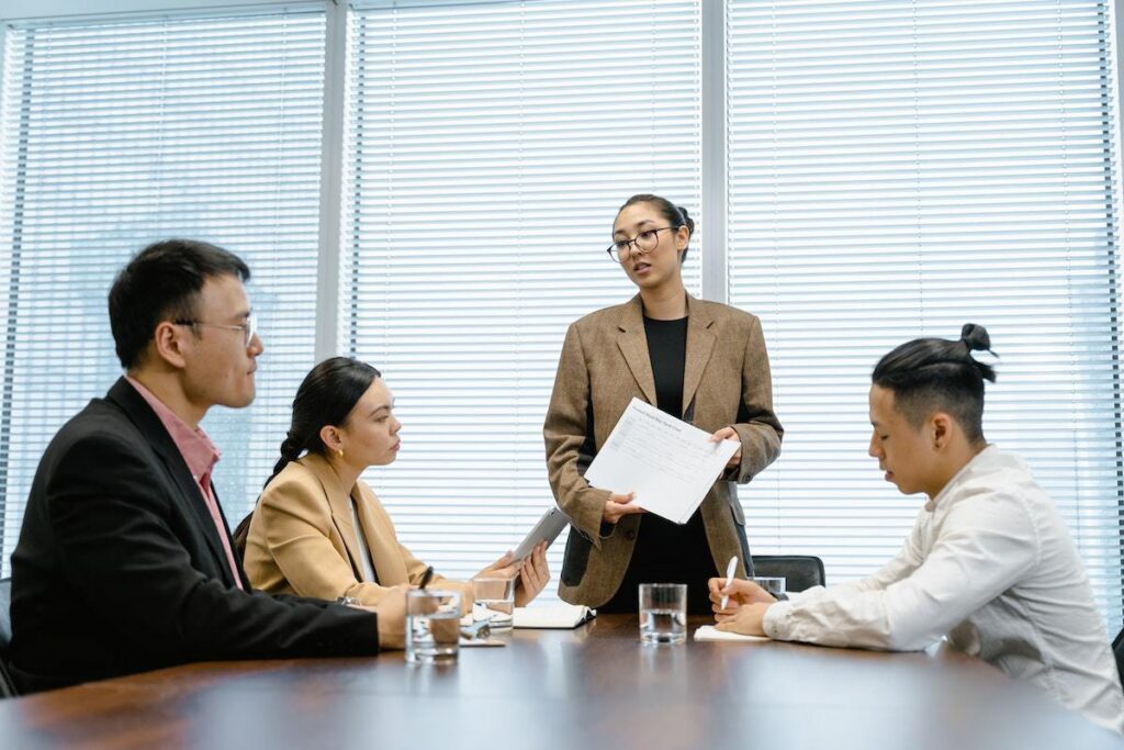 Pessoas em reunião em ambiente de trabalho com líder do sexo feminino ministrando a mesma