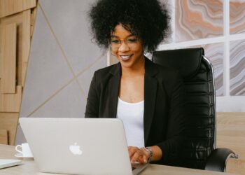 Imagem de uma mulher olhando para a tela do notebook sorrindo