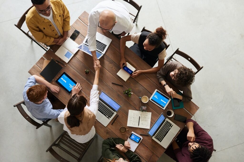Empresas: A imagem retrata pessoas em uma mesa de trabalho.