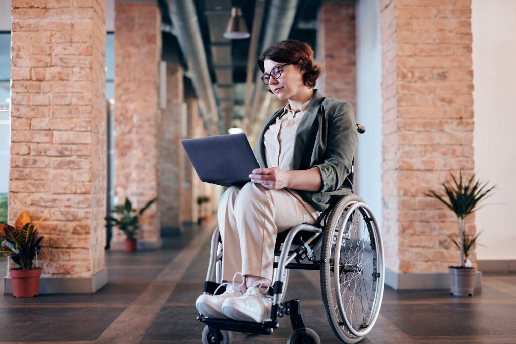 Palestras sobre inclusão digital: A imagem retrata uma cadeirante utilizando de um notebook. 