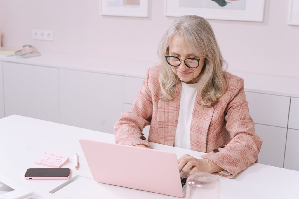 Palestras sobre inclusão digital: A imagem retrata uma mulher idosa na frente de um notebook, acessando a internet. 