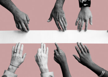 Nove mãos sobre faixa branca com superfície rosa e pessoas com mãos que faltam alguns dedos em representação à inclusão