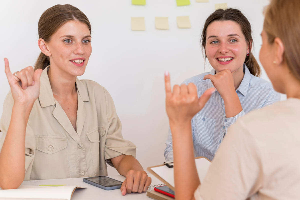 Mulheres conversando em língua de sinais em empresa como Exemplo de inclusão