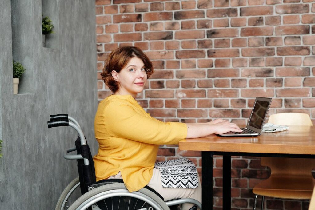 imagem ilustra uma mulher cadeirante atuando em um escritório, mostrando que a diversidade é o futuro das empresas